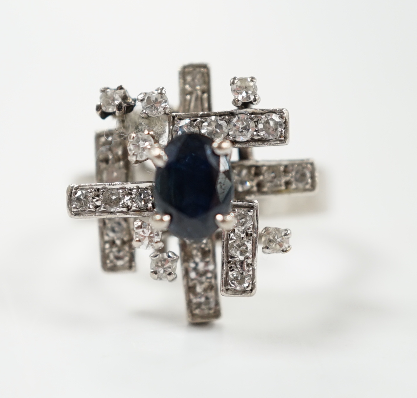 A modern 18k white metal, sapphire and diamond set modernist ring, size K/L, gross weight 6.1 grams.